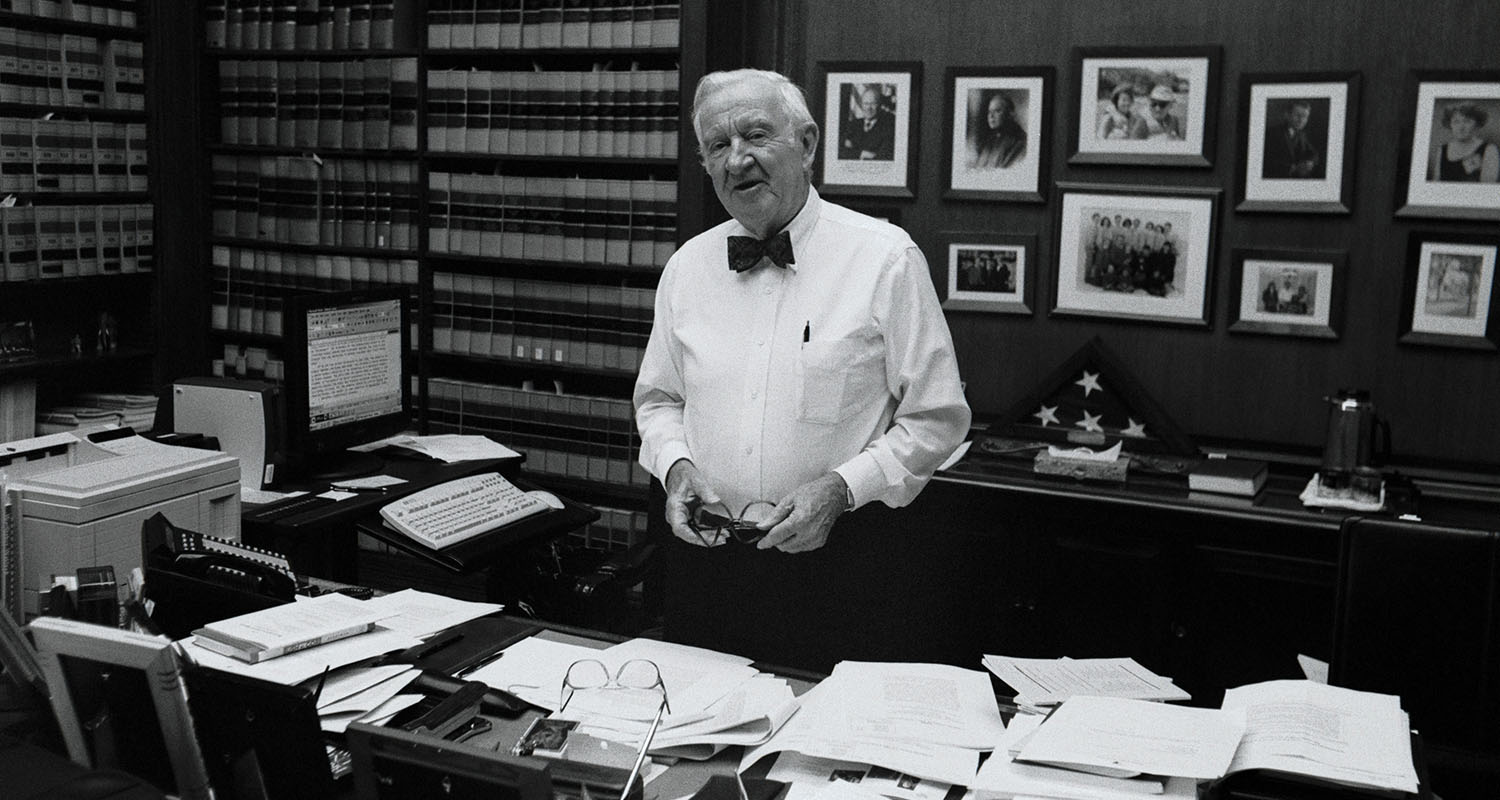 Justice Stevens in his office surrounded by papers, pictures, and law books